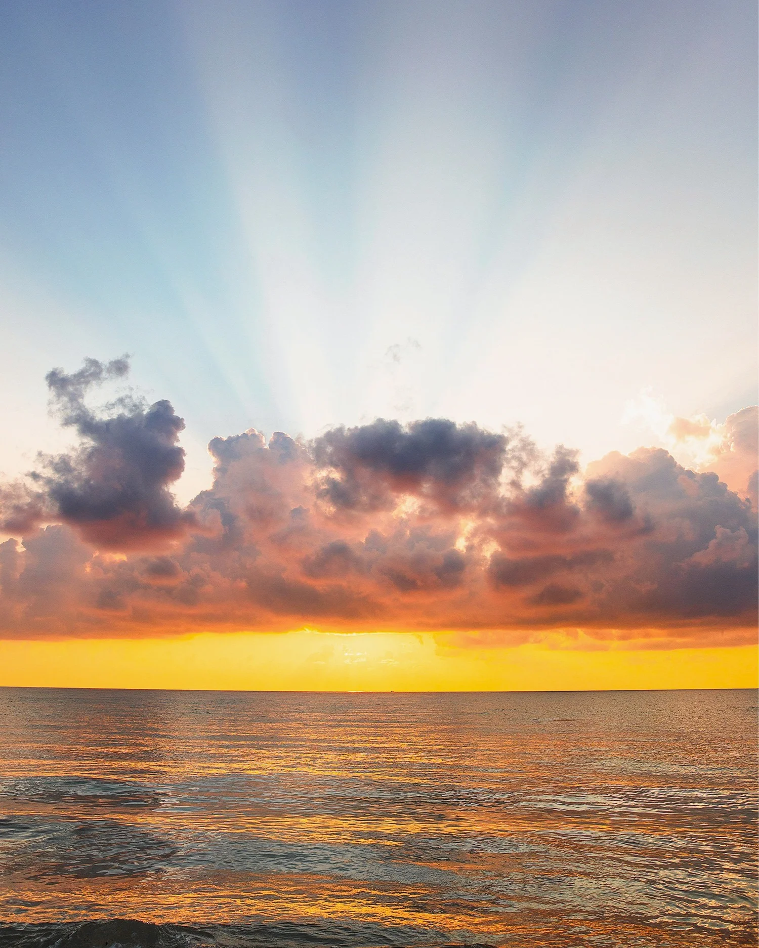 Sunlight breaking through clouds above water