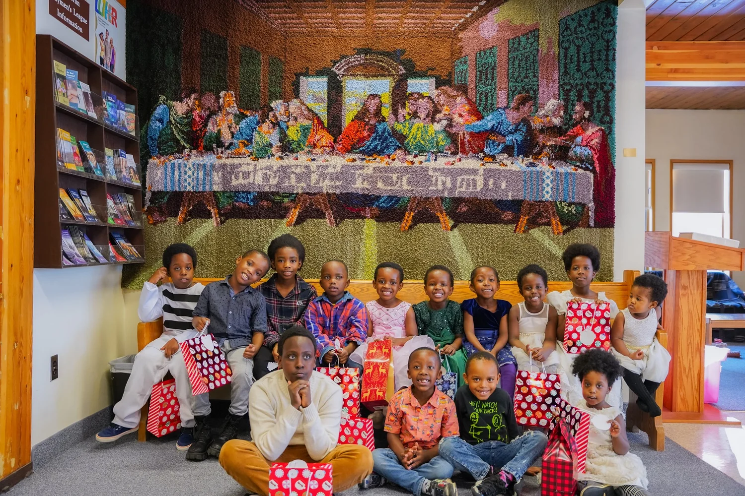 A youth group gathered in front of a wall display